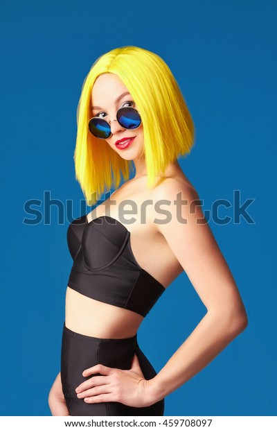 Unusual Yellow Hair. Haircut.\
Beautiful Girl in sunglasses and sexy underwear. Hairstyle Bob.\
Portrait of Fashion Beauty young Woman over blue\
background