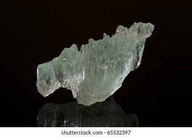 Unusually perfect piece of aquamarine on a black reflective surface. This rough sample has no anchor point with another rock. - Shutterstock ID 65532397