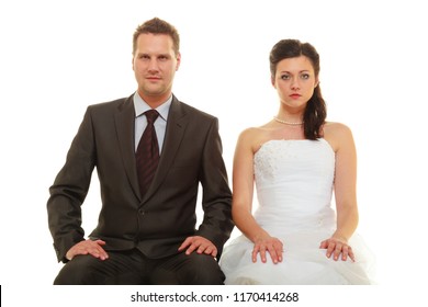 Unwanted Marriage, Bad Life Decisions Concept. Serious Groom In Suit And Bride Wearing White Dress Sitting Together And Waiting For Wedding, Isolated.