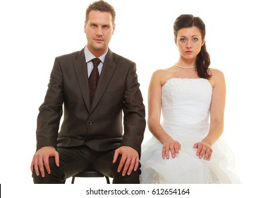 Unwanted Marriage, Bad Life Decisions Concept. Serious Groom In Suit And Bride Wearing White Dress Sitting Together And Waiting For Wedding, Isolated.