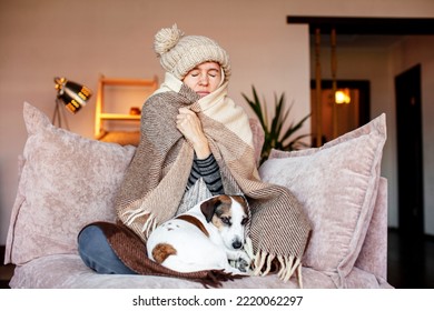 Unwell woman in blanket sit in cold living room. Suffering from lack of heat at home . Unhealthy young woman struggle from chill freeze at home. No heating concept - Shutterstock ID 2220062297