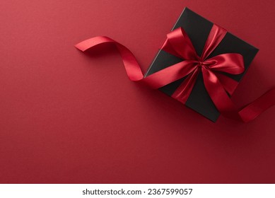 Unwrap savings this Black Friday! Top view of a lavish black gift box tied with a red ribbon, set on a marsala backdrop, providing space for your message or promotion - Powered by Shutterstock