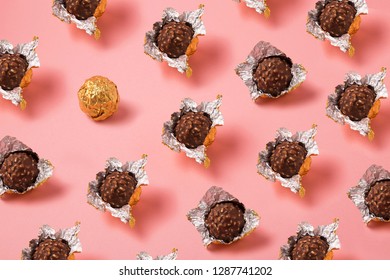 Unwrapped Chocolate Balls In Gold Foil On Pink Background, Praline In Open Wrapper Foil 