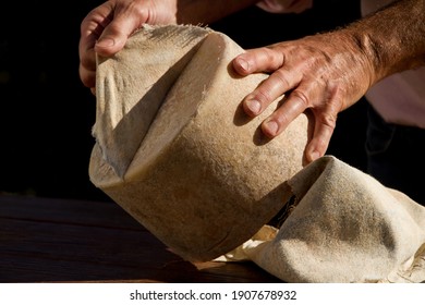 Unwrapping cloth off chesire cheese with a black background - Powered by Shutterstock