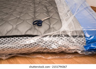 Unwrapping New Mattress From Its Plastic Wrap With Scissors, It Expands Quickly.