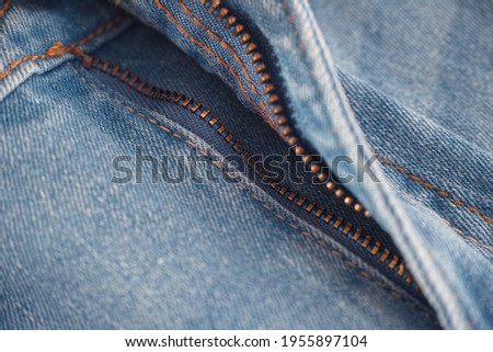 An unzipped zipper on a pair of jeans. Close up.