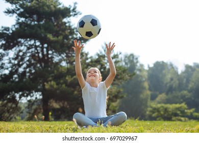 Upbeat Girl Throwing A Ball In The Air