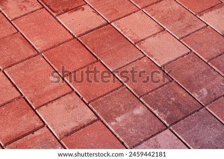 An upclose shot of a diagonal patterned red brick floor, resembling brown brickwork. The rectangular shapes create a unique flooring design