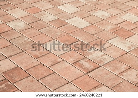 An upclose shot of a diagonal patterned red brick floor, resembling brown brickwork. The rectangular shapes create a unique flooring design