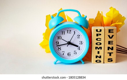 Upcoming event word with wooden blocks concept with clock and yellow foliage on white background - Powered by Shutterstock