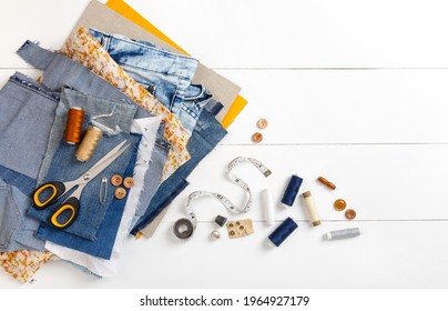 Upcycle old denim garbage. Recycling old jeans. Old blue jeans cut pieces and sewing materials ready for recycling and scissors on white background. Circular economy. Zero waste banner with copy space - Powered by Shutterstock