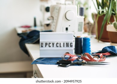 Upcycling Text On Light Board On Sewing Machines With Old Blue Jeans Background. Denim Clothes, Scissors, Thread And Sewing Tools In Sewing Studio. Denim Upcycling And Repair