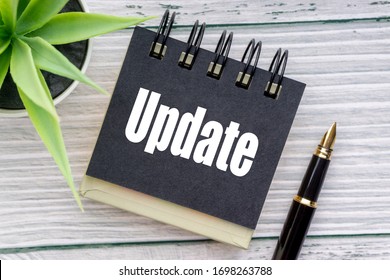 UPDATE Text With Decorative Flower, Fountain Pen And Notepad On Wooden Background. Business Concept