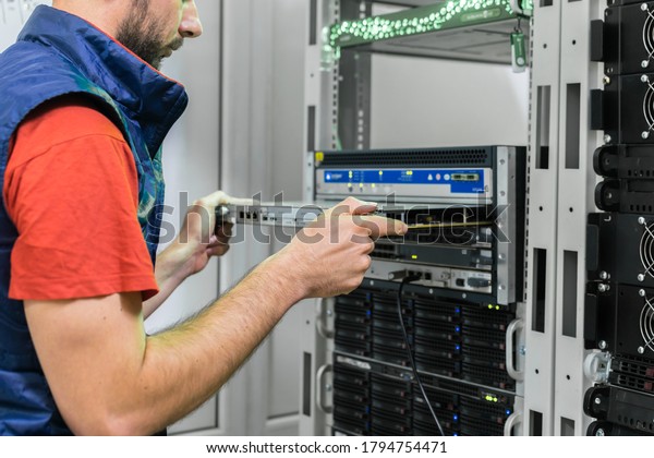 Updating the hardware part of the data center\
server room.The technician installs a new server board in the ISP\'s\
central router