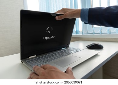 Updating Software Technology Upgrade Concept. A Businessman Opens A Modern Ultrabook On Which The Operating System Is Being Updated.