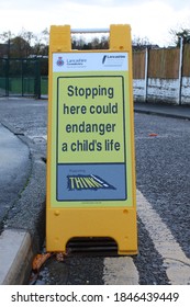 Upholland, Lancashire, UK, November 2020: Stopping Here Could Endanger A Child's Life, Road Safety Sign On Double Yellow Lines, School Gates Blurred In Background