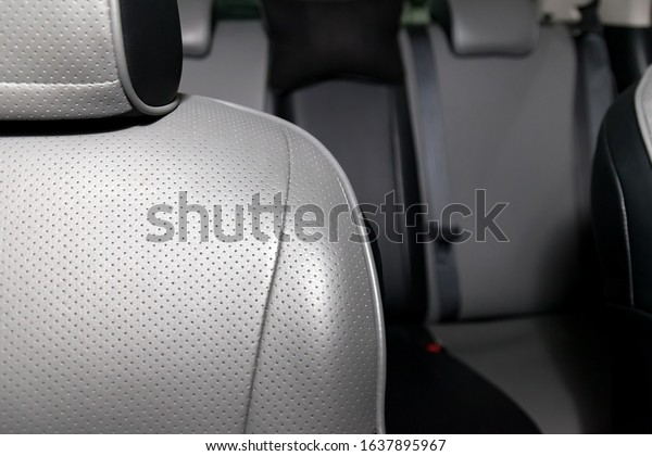 Upholstery of the seats of the\
passenger compartment of a luxury car with gray perforated genuine\
leather in a workshop for hauling vehicles with a seam of\
thread.