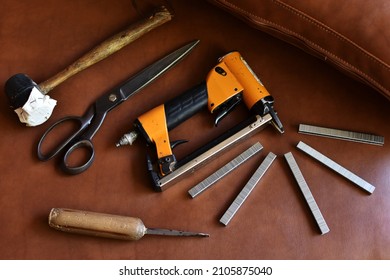 Upholstery tools on brown background, flat layer.