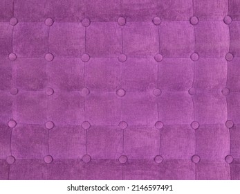 upholstery of velour buttoned purple violet color fabric, wall pattern. Elegant vintage quilted sofa background. Interior 