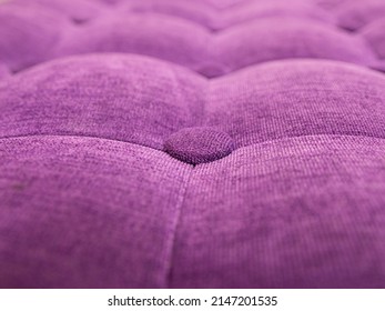 upholstery of velour buttoned purple violet color fabric, wall pattern. Elegant vintage quilted sofa background. Interior 