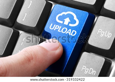 Uploading file. gesture of finger pressing upload button on a computer keyboard