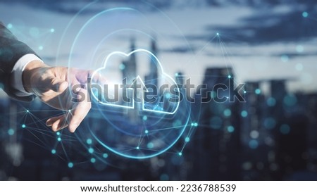 Uploading files to cloud concept. Close up of businessman hand pointing at hologram on blurry city skyline background. Double exposure