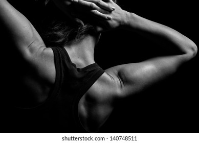 Upper body of a muscular woman from the back in a studio