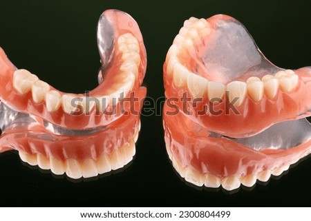 Upper and lower complete dentures isolated on black background