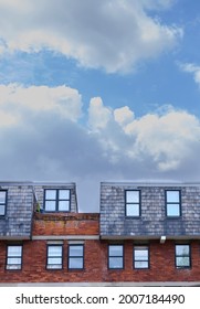Upper part of an bricks building with blue cloud sky
