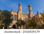 Upper part of main facade of the Dohany Street Synagogue, or Great Synagogue built in 19th-century with two towers with domes at autumn sunny morning, Budapest, Hungary 
