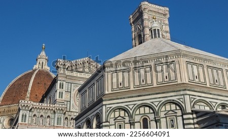 Upper part of UNESCO Complex in Piazza del Duomo of Florence. Baptistery of Saint John next to the Florence Cathedral of Saint Mary of the Flower, with red-tiled roof or cupola, Giotto bell tower.