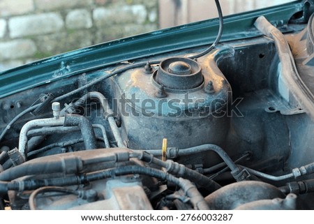 The upper support of the front shock absorber strut and fragments of the engine of a Mazda 626, demonstrating the technical condition of the components and assemblies under the hood.