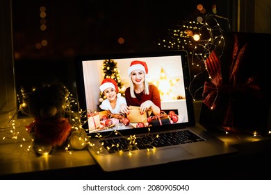 Upper view of modern family sitting on couch in the modern living room at Christmas on laptop