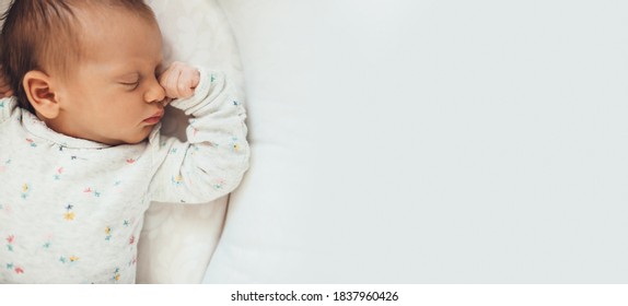 Upper view photo of a newborn baby sleeping well in bed near free space