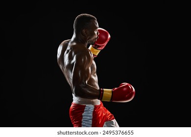 Uppercut punch. Determined muscular man with sweating strong body, boxing athlete in motion, fighting isolated on black background. Concept of professional sport, active lifestyle, body, strength - Powered by Shutterstock