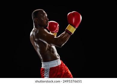 Uppercut punch. Motivated and ambitious sportsman, muscular boxer in motion fighting, training shirtless in gloves isolated on black background. Concept of sport, active lifestyle, body, strength - Powered by Shutterstock