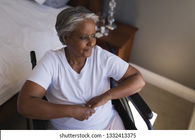 Upper-section of a thoughtful disabled senior African American woman looking worried through window at home - Powered by Shutterstock