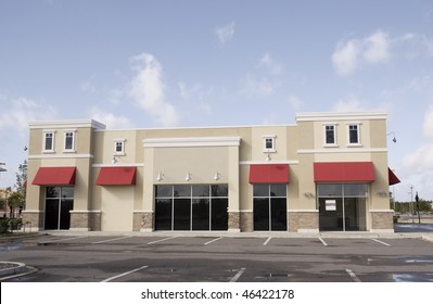 Upscale Pastel Strip Mall Building With Red Awnings And Tinted Glass