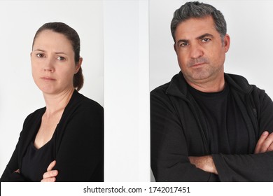 Molesta pareja adulta de entre 30 y 40 años teniendo una pelea en casa apoyándose en un muro de separación mirando la cámara.