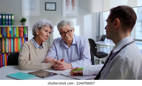 Upset aged couple consult oncologist in modern medical center. Doctor tell bad diagnosis to sad senior patients - Shutterstock ID 2144706057