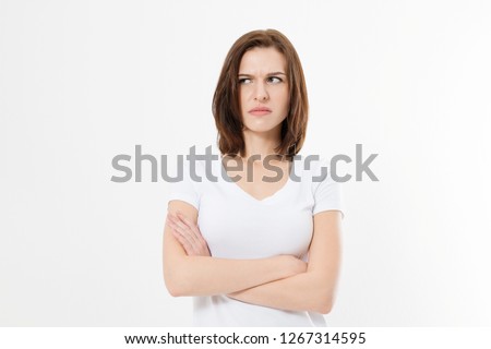 Upset and angry girl in white blank t shirt isolated on white background. Sad and mad woman with crossed arms . Copy space.