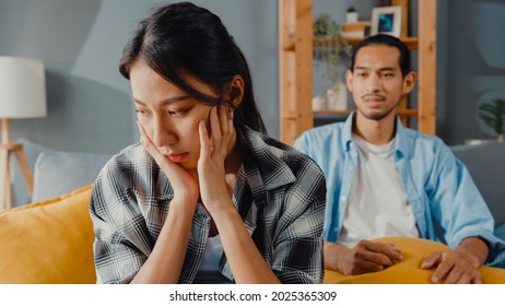 Upset asian couple wife sit on couch listen to furious husband yelling feel unhappy talk negative to her. Couple have fight or disagreement at home, Couple problem, family married toxic relationship. - Shutterstock ID 2025365309