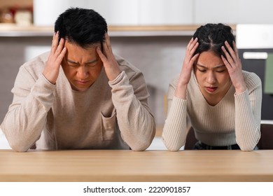 Upset Asian Spouses Sitting At Kitchen Desk At Home, Touching Heads And Looking Down, Poor Hungry Asian Family Husband And Wife Starving, Have Nothing To Eat During 2022 Crisis, Closeup Portrait