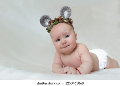 Upset Baby Girl In Lying On Tummy Wearing Mouse Ears Hat