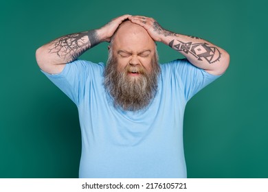 Upset Bearded Man With Overweight Touching Bald Head Isolated On Green