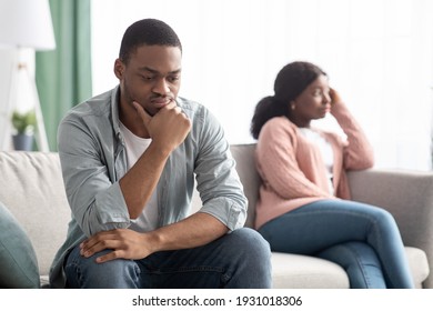 Upset black couple young man and woman having relationships crisis, sitting on couch and looking aside, sad african american family thinking about divorce. Crisis in marriage concept