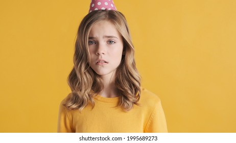Upset blond teenage girl looking sad want to cry from despair celebrating her birthday alone isolated on yellow background