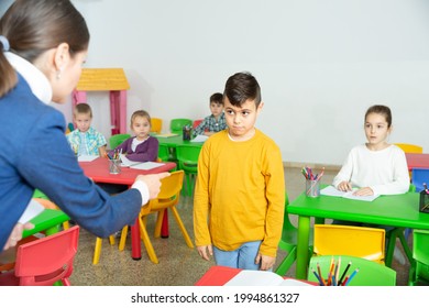 Upset Boy Listening Reprimanding Of Strict Female Teacher During Lesson In Primary School