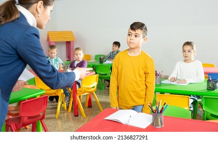 Upset Boy Listening Reprimanding Of Strict Female Teacher During Lesson In Primary School