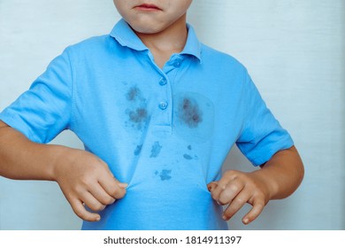 Upset Boy Showing A Stain On His Clothes The Concept Of Cleaning Stains On Clothes. Isolated On A White Background